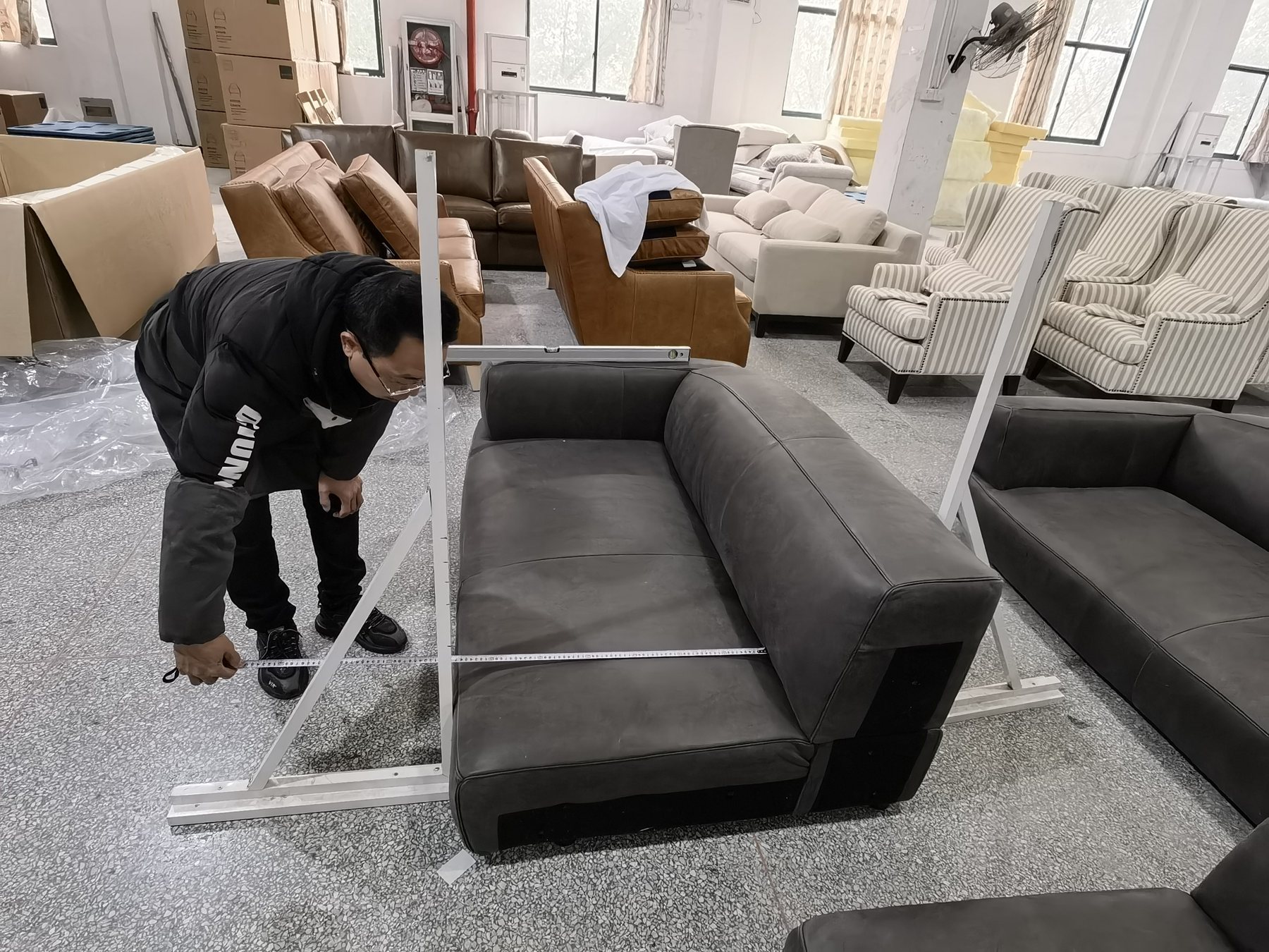 Finished sofa dimension inspection with measuring tool