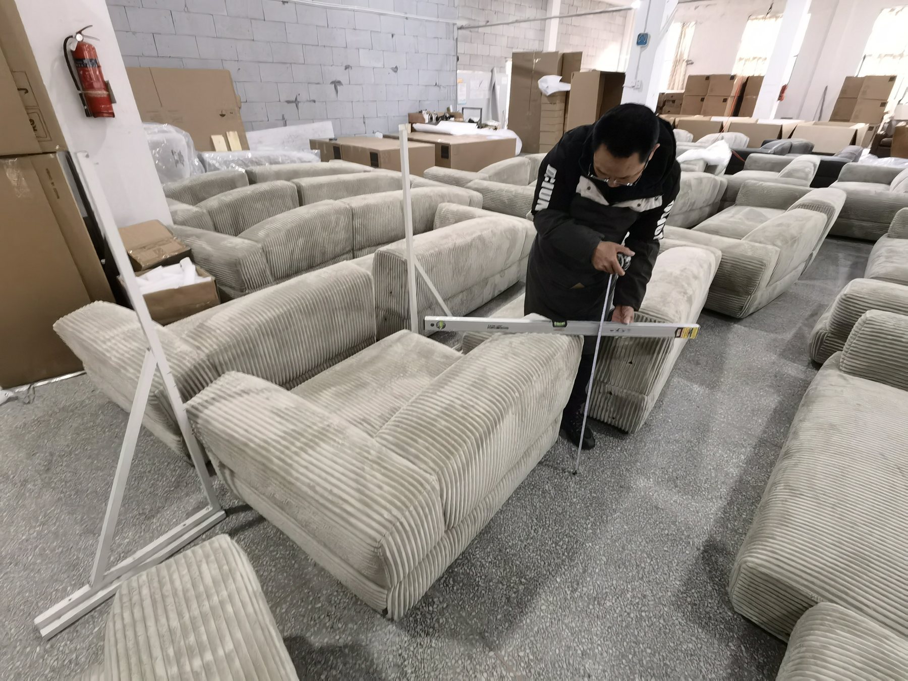 Upholstered sofa being measured during final inspection